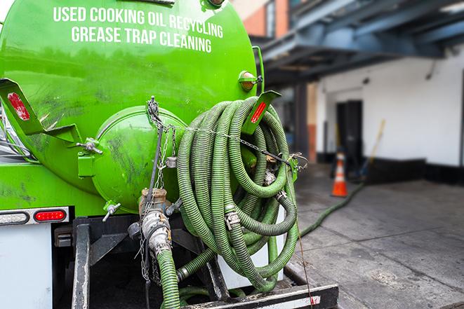 a professional technician pumping a restaurant's grease trap in Fort Myers Beach, FL